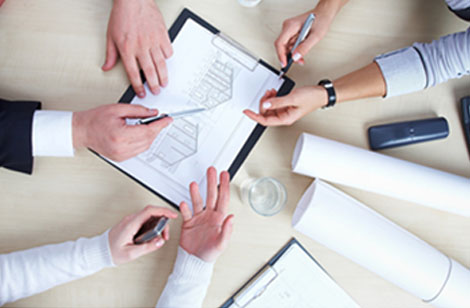 Group of persons gathered around a workstation